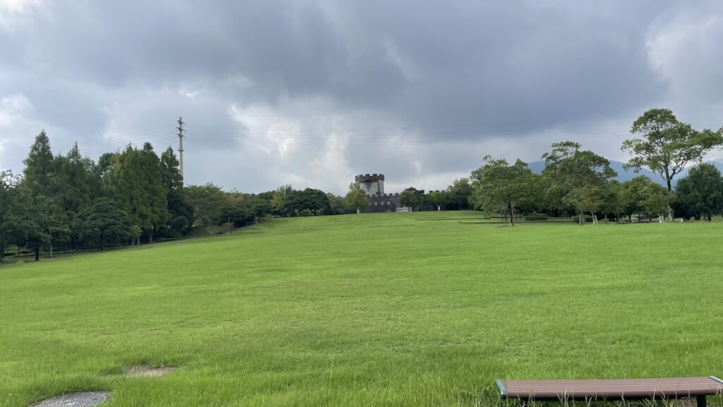 Wide open green lawn with a castle-like observation tower at Hyakkadai Park in Unzen