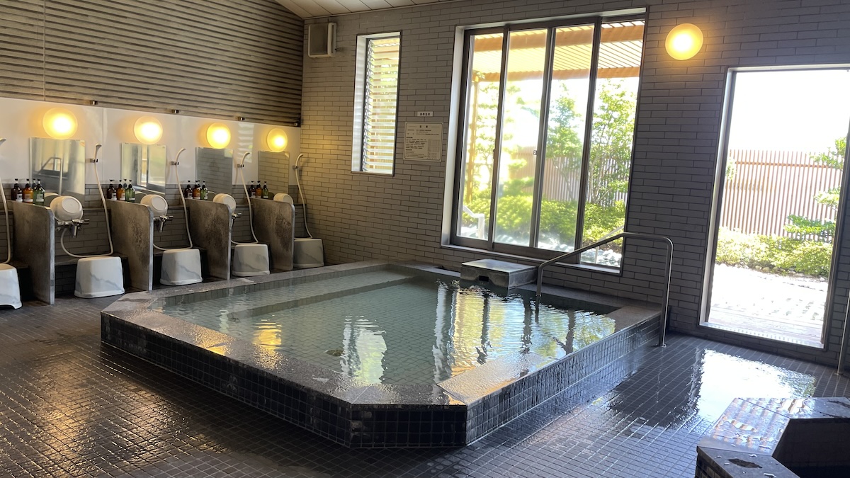 Spacious indoor communal hot spring bath with washing area at Hotel Seaside Shimabara