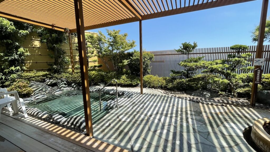 Open-air hot spring under wooden pergola at Hotel Seaside Shimabara