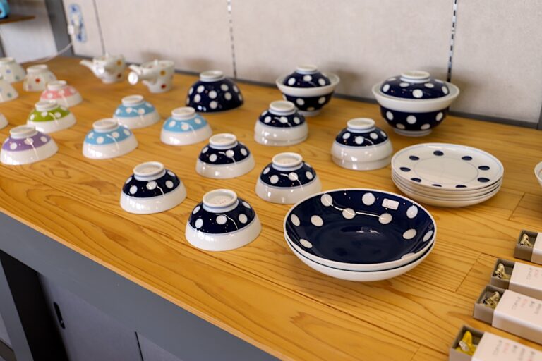 Colorful Yoshida ware bowls and plates with polka dot patterns on display