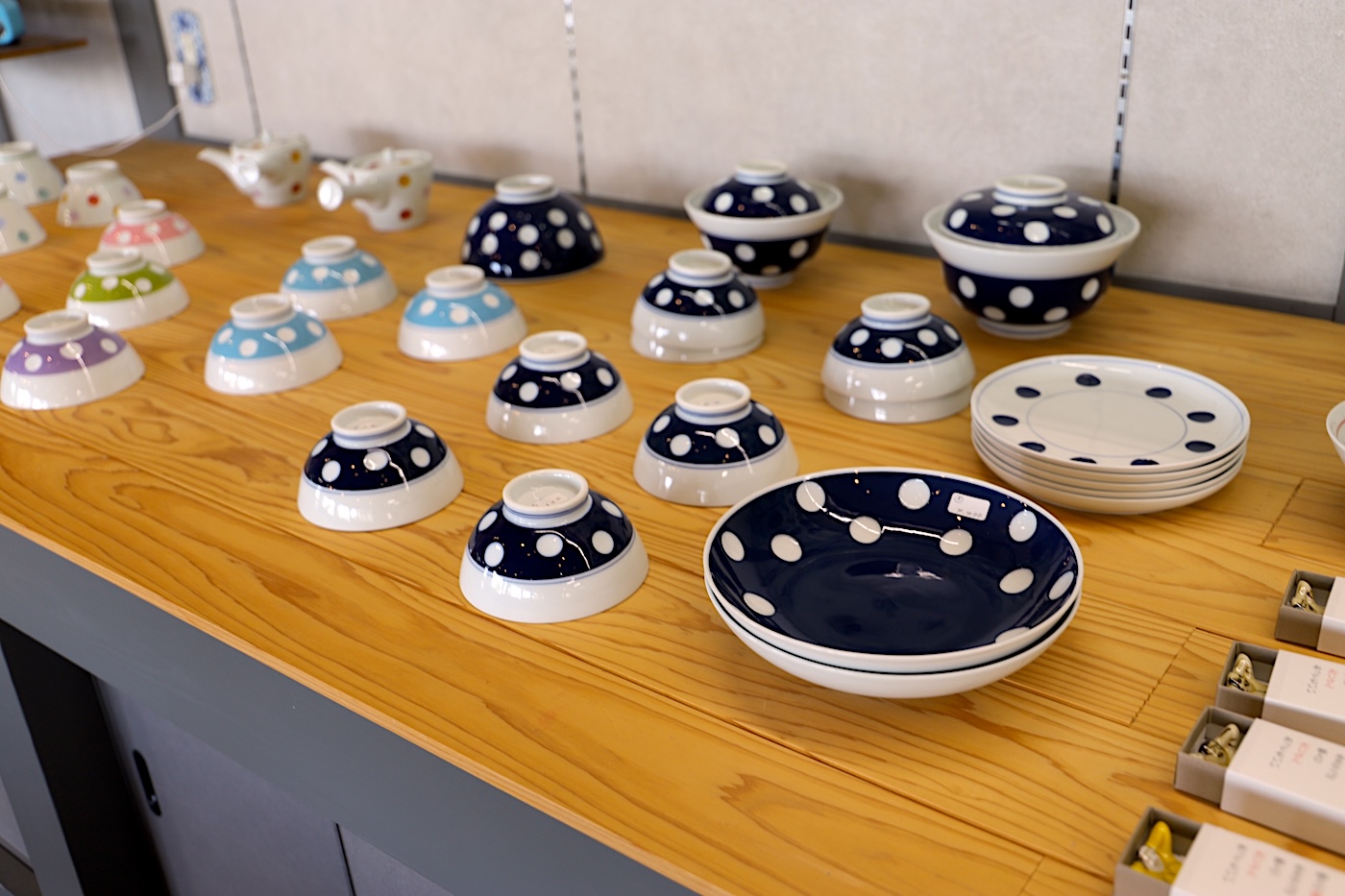 Colorful Yoshida ware bowls and plates with polka dot patterns on display