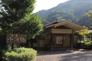 Traditional ryokan building with mountains in the background