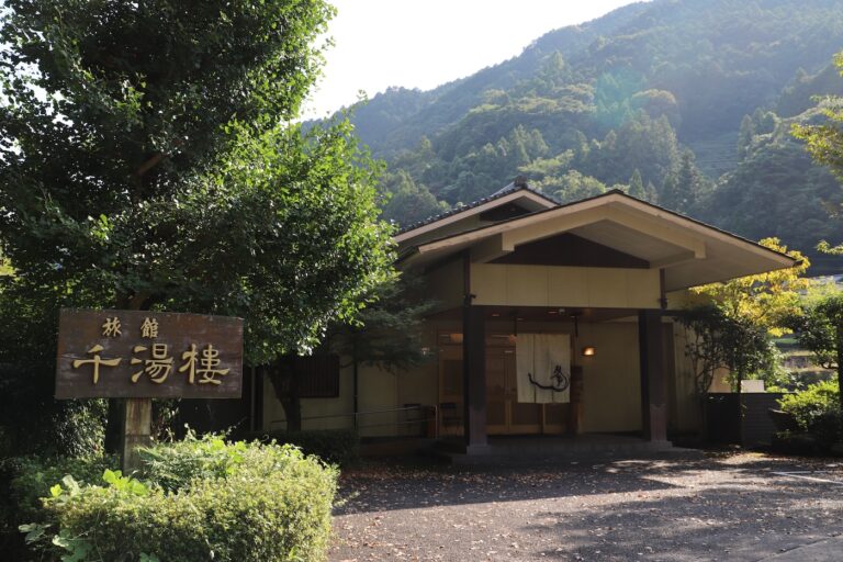 Traditional ryokan building with mountains in the background