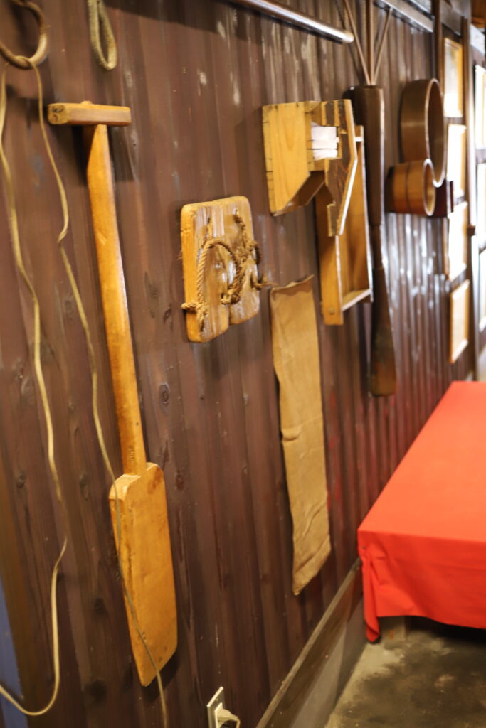 Traditional wooden sake brewing tools displayed on the wall inside Mitsutake Sake Brewery in Kashima, Saga.