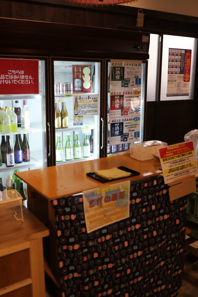 Sake tasting counter with refrigerated bottles inside Mitsutake Sake Brewery in Kashima, Saga.