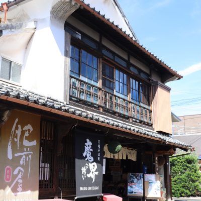 The Historic Exterior of Mitsutake Brewery The traditional exterior of Mitsutake Brewery in Kashima, Saga, with noren curtains and sugidama at the entrance.