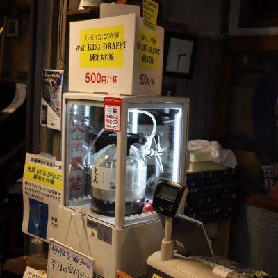 Fresh Draft Sake Experience Freshly pressed sake keg draft dispenser at Mitsutake Sake Brewery, offering Junmai Daiginjo for 500 yen per cup.